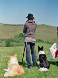 Hundehalterin mit zwei Hunden auf der Wiese – Übergangsjacke und Jeans bei mildem Wetter